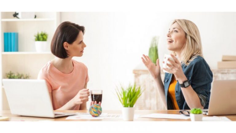 Zwei Frauen in einer Unterhaltung am Tisch