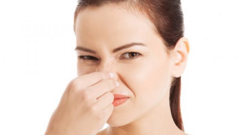 Frau hält sich die Nase