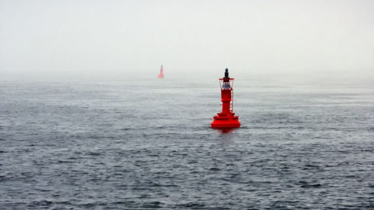 Bojen Zwei rote Bojen im Meer, der Himmel ist bedeckt