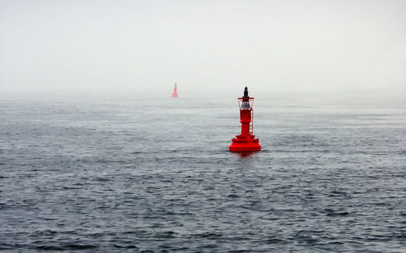 Bojen Zwei rote Bojen im Meer, der Himmel ist bedeckt