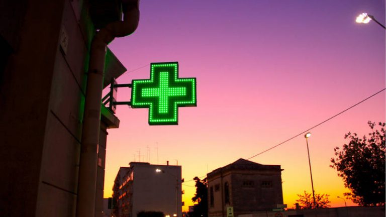 Grünes Kreuz in der Abenddämmerung bei orange-lila Himmel