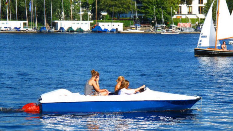 Tretboot mit drei Menschen auf einem See