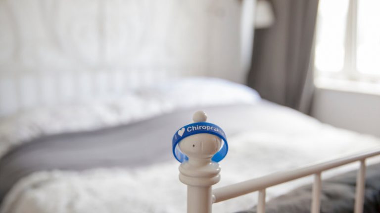 An einem Bettpfosten hängt ein blaues Gummiarmband