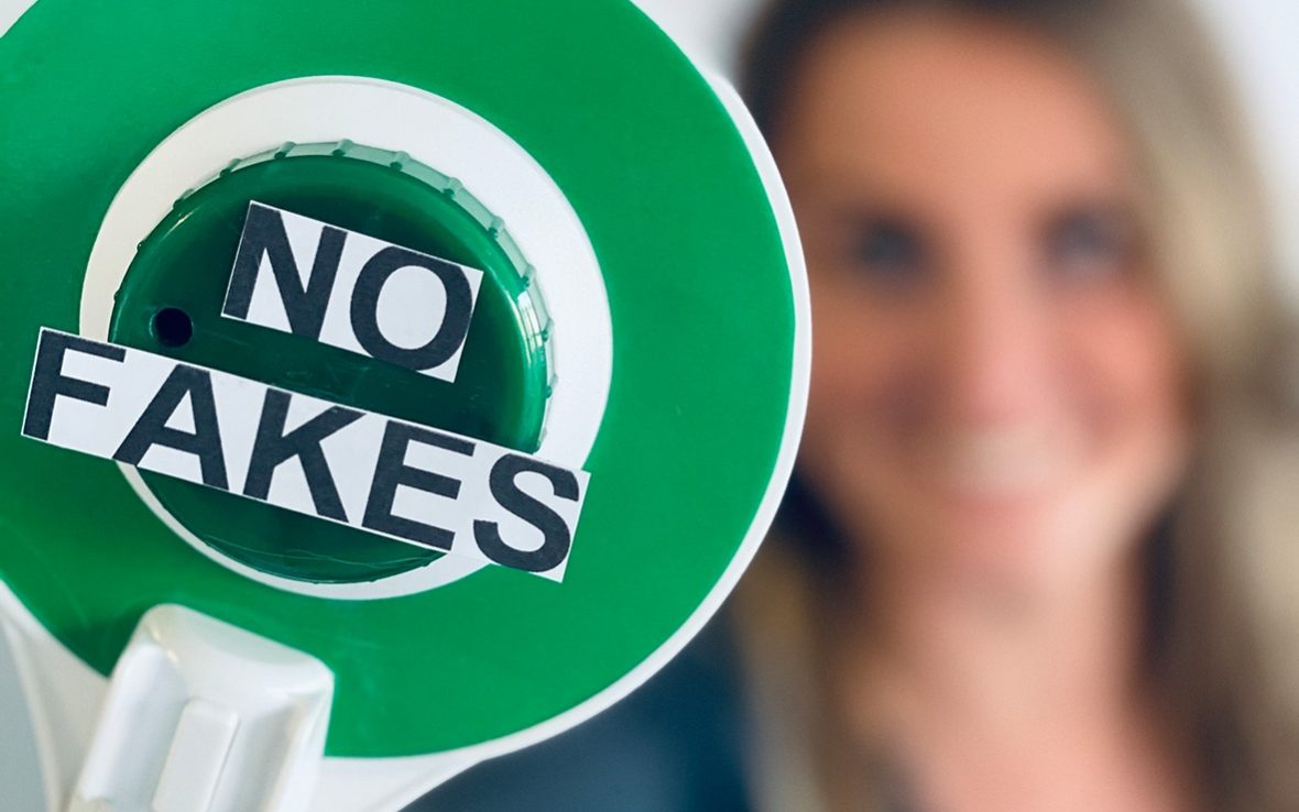 Sentryc No Fakes Makroaufnahme einer Polizeikelle mit der Aufschrift "No Fakes"