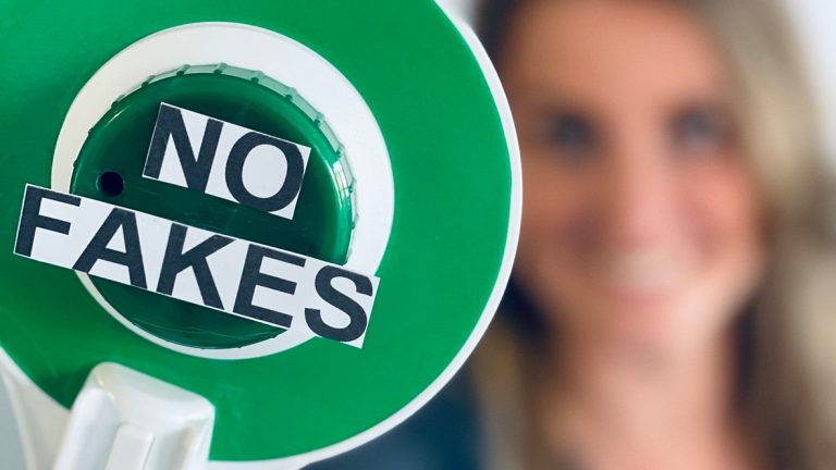 Sentryc No Fakes Makroaufnahme einer Polizeikelle mit der Aufschrift "No Fakes"