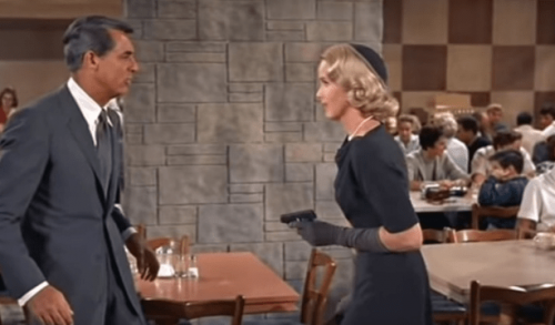 Eine Filmszene aus dem Film Der unsichtbare Dritte, ein Mann und eine Frau stehen sich in einem Restaurant gegenüber