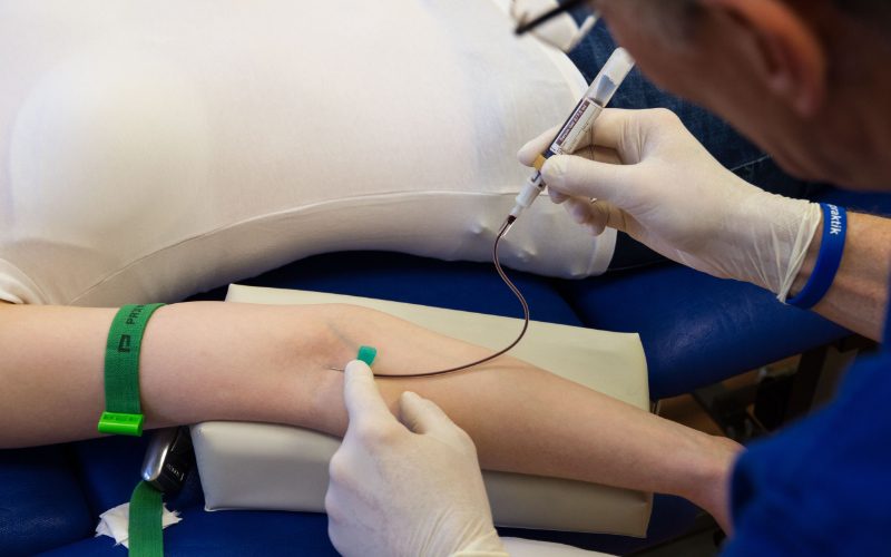 Labordiagnostik mittels Blutentnahme Eine medizinische Fachkraft nimmt einem Patienten, von dem nur der Arm zu sehen ist, Blut ab.