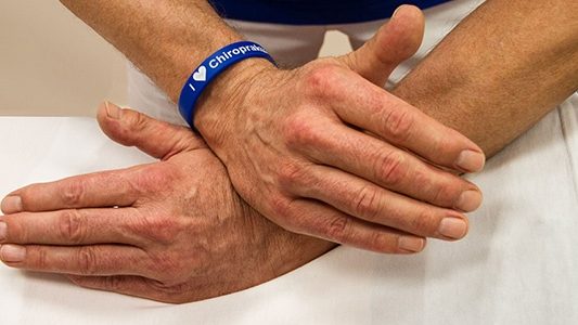 Großaufnahme von zwei Händen bei einer Justierung im Rückenbereich.