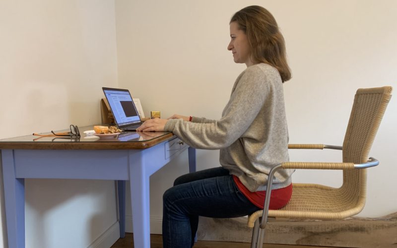 faktwert tik am tibarg tipps homeoffice haltung Marei Schachschneider trägt einen grauen Pulli und sitzt auf dem Stuhl vor einem Laptop.