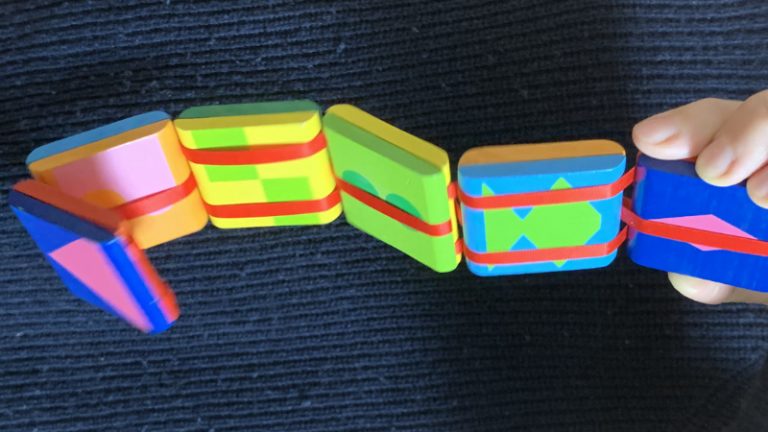 Eine bunte viereckige Spielzeugraupe auseinander gezogen.