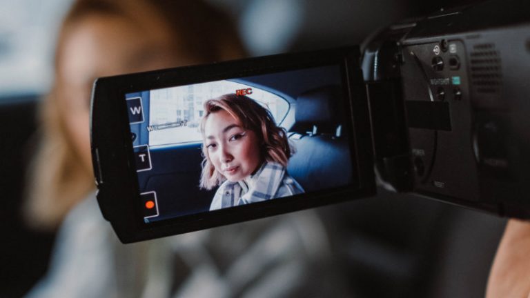 Aufnahme einer asiatischen Frau gezeigt in dem aufgeklappten Display einer Videokamera