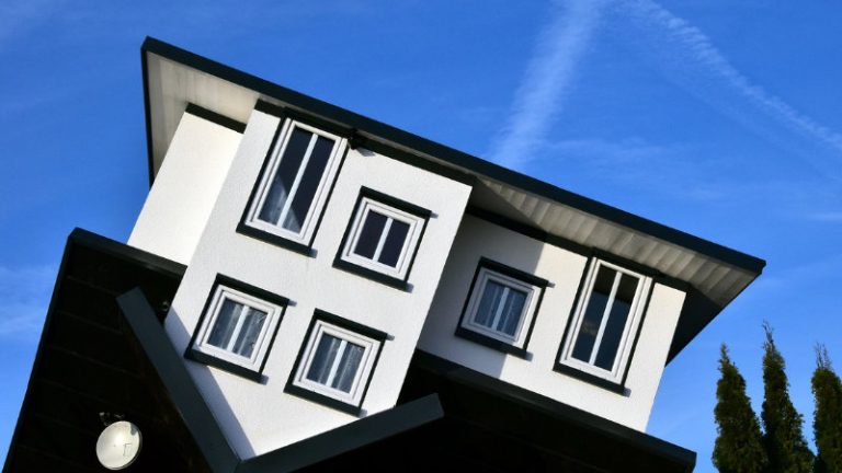 Umgedrehtes Haus mit schwarzen Dach und schwarzen Festerrahmen.