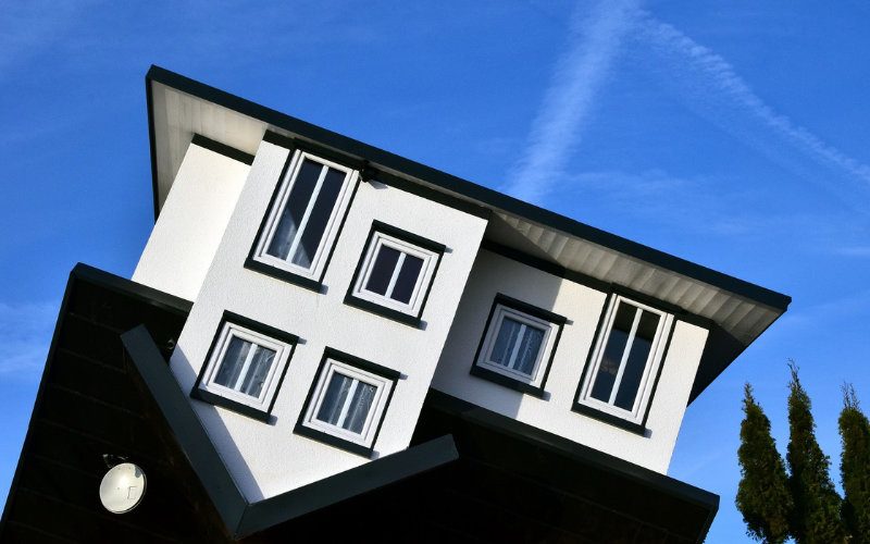 Umgedrehtes Haus mit schwarzen Dach und schwarzen Festerrahmen.