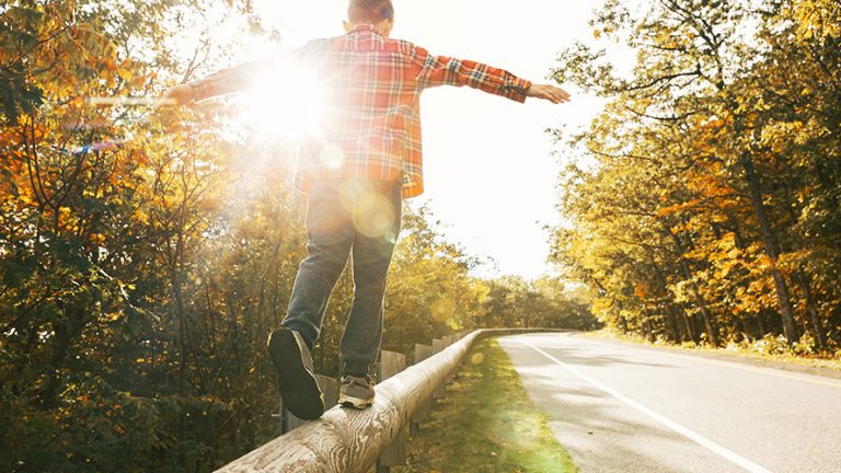 boy, balance Ein Junge im karierten Hemd balanciert auf einem Holzbalken