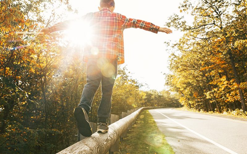 boy, balance Ein Junge im karierten Hemd balanciert auf einem Holzbalken