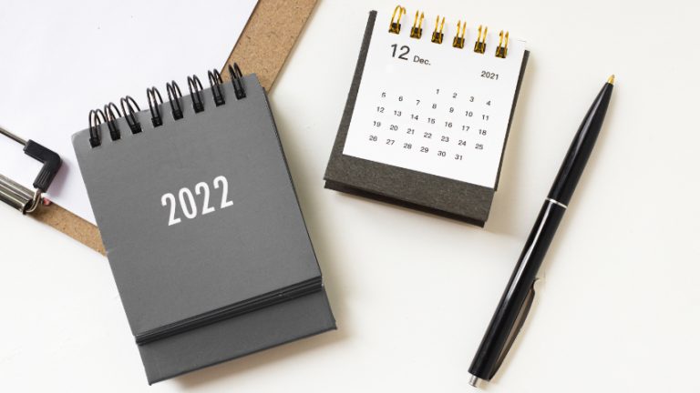 Ein grauer Kalender für das Jahr 2022 und ein schwarzer Stift