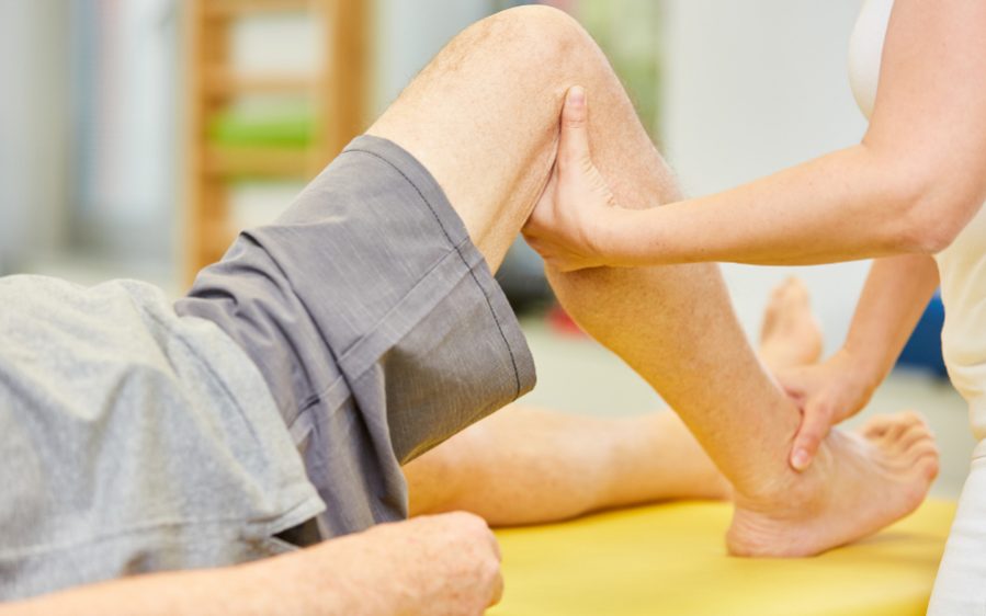 BildreAdobeStock: 354539496 / Thema: Chronische Schmerzen erfolgreich behandeln durch multimodale Schmerztherapie Physiotherapeutin behandelt Kniegelenk mit Osteopathie als Methode der Alternativmedizin