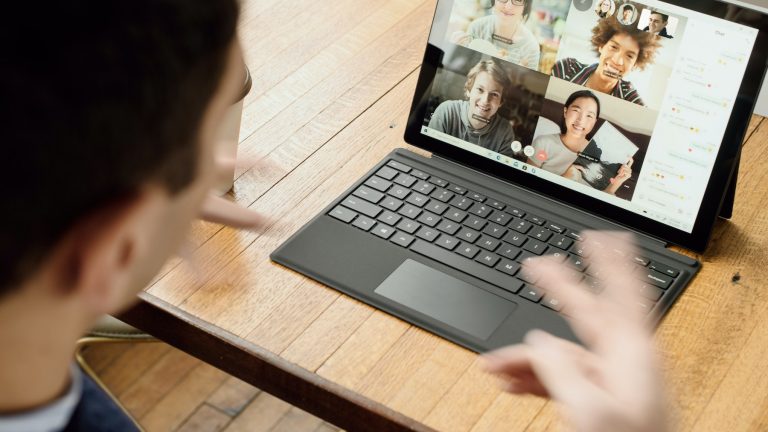 faktwert_Kroll Languages_Remote Work_Bildrechte Unsplash_Surface Kopie Ein Mann sitzt vor seinem Laptop bei einer Videokonferenz.