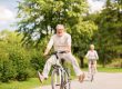 aktives Alter, Menschen und Lifestyle-Konzept - glückliches Seniorenpaar beim Fahrradfahren im Sommerpark