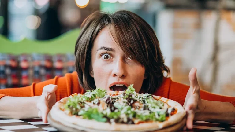 Frau mit Pizza in einem Restaurant