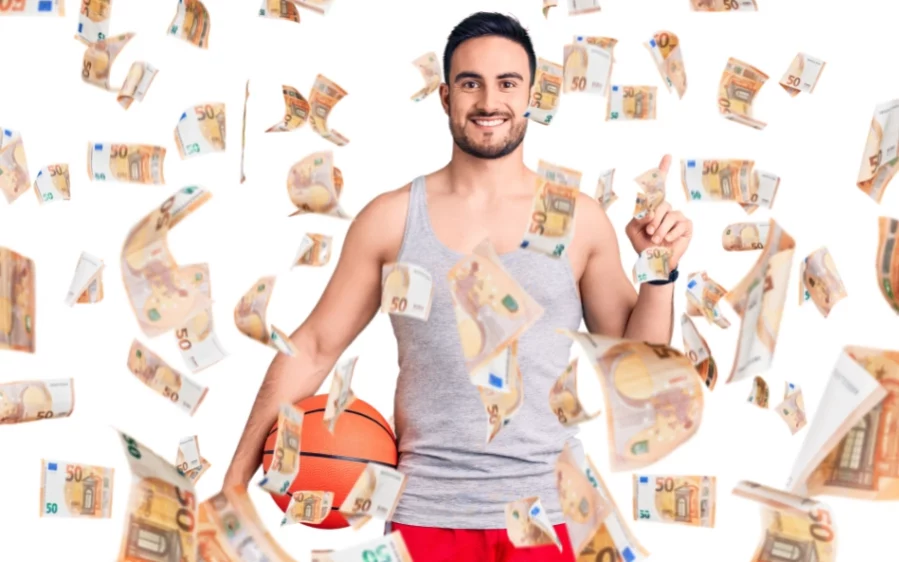 Sport und Wohlbefinden_900x600 Ein junger Mann hält einen Basketball zwischen Arm und Hüfte. Um ihn herum fliegen viele 50€-Scheine.
